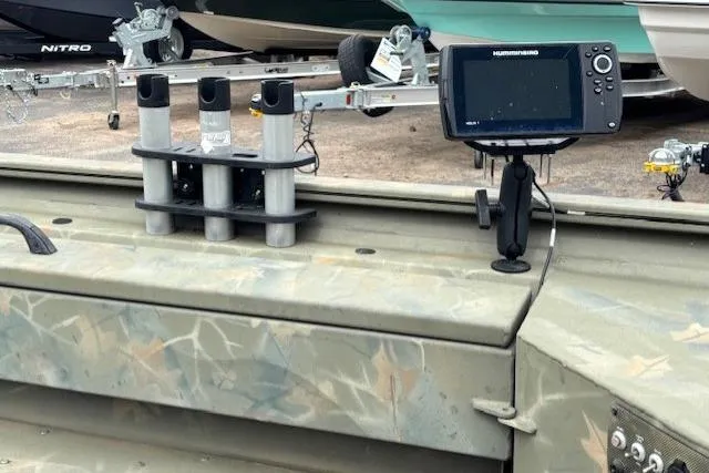 Slide: The Image of 2017 Tracker Grizzly 1654 MVX Sportsman boat with mounted fish finder and rod holders. - 11