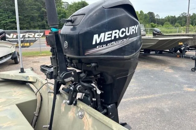 Slide: The Image of 2017 Tracker Grizzly 1654 MVX Sportsman with Mercury FourStroke outboard motor in a parking lot. - 12