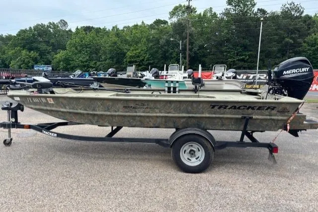Slide: The Image of 2017 Tracker Grizzly 1654 MVX Sportsman boat on trailer, parked outdoors. - 5