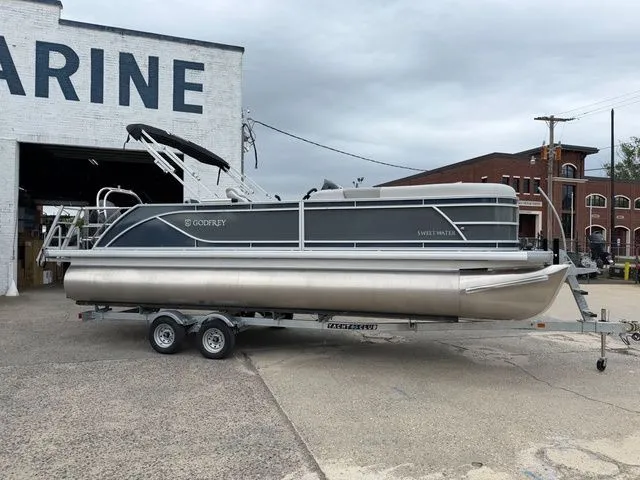 Slide: The Image of Godfrey Sweetwater 2286 SFL Tritoon 2026 on trailer outside marine building. - 4