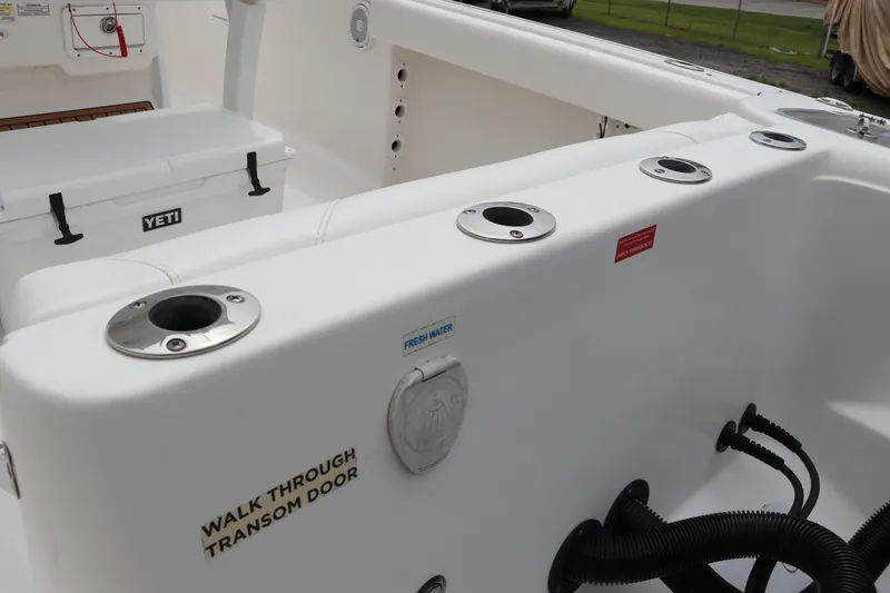 Slide: The Image of 2017 Tidewater 252 CC Adventure boat interior with rod holders and Yeti cooler. - 11