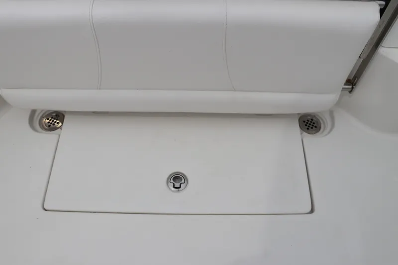Slide: The Image of 2017 Tidewater 252 CC Adventure boat interior with white seating and storage compartment. - 16