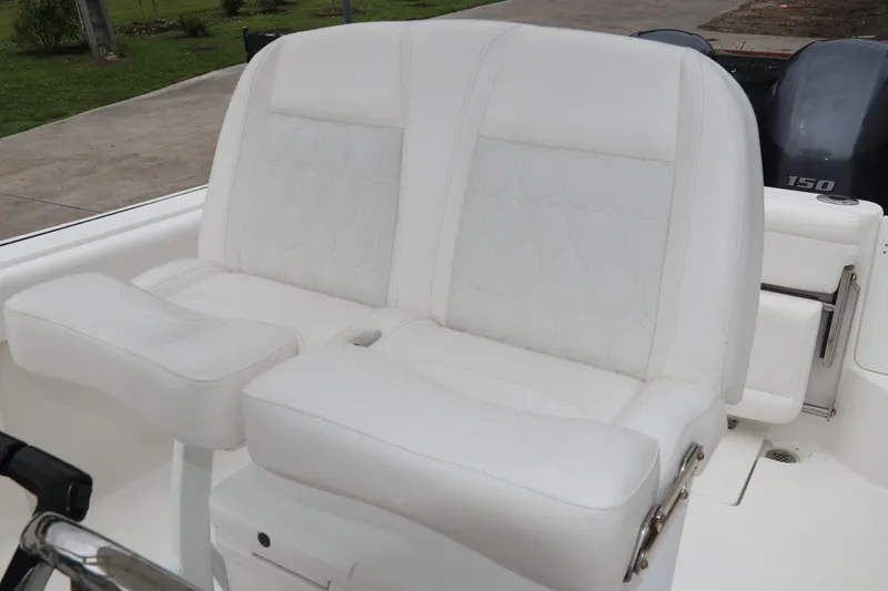 Slide: The Image of White leather seating on 2017 Tidewater 252 CC Adventure boat, featuring dual outboard motors. - 21