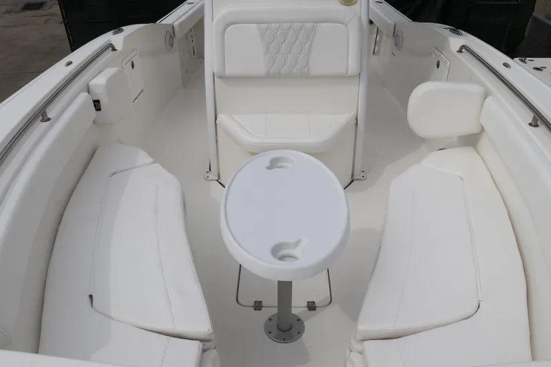 Slide: The Image of 2017 Tidewater 252 CC Adventure boat interior with white seating and table. - 43