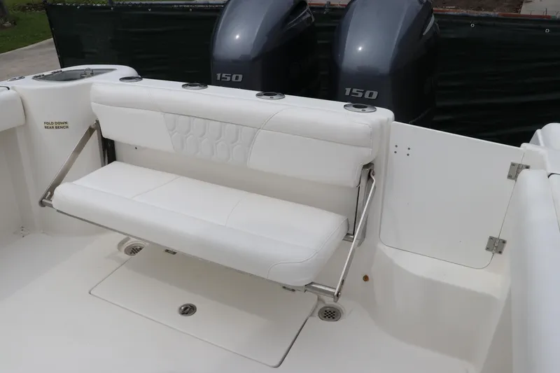 Slide: The Image of 2017 Tidewater 252 CC Adventure boat with dual 150 horsepower engines, parked on grass. - 6