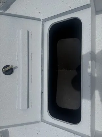 Slide: The Image of 2026 Xpress Boats H20B storage compartment with open lid. - 10
