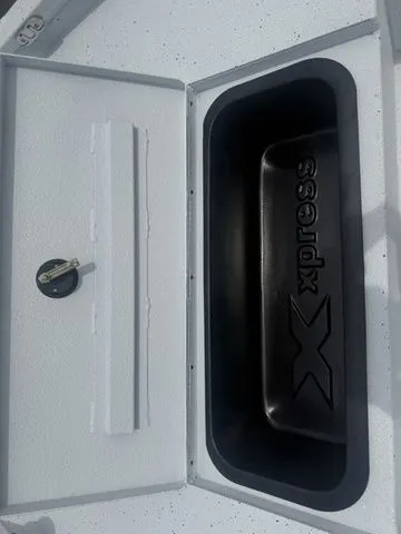 Slide: The Image of Xpress Boats H20B 2026 storage compartment with logo and lock. - 9