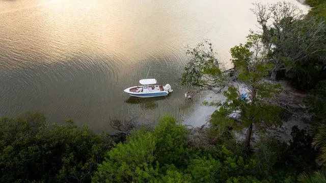 Slide: The Image of Aerial view of Sea Hunt Ultra 235 SE boat in tranquil cove, 2026 model. - 7