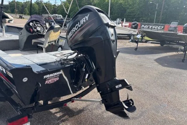 Slide: The Image of 2013 Tracker Super Guide V-16 SC boat with Mercury outboard motor in a parking lot. - 3