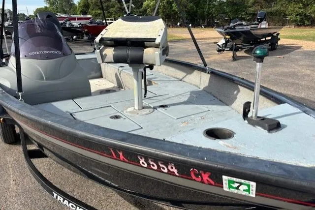 Slide: The Image of 2013 Tracker Super Guide V-16 SC fishing boat with seating and storage, parked outdoors. - 7
