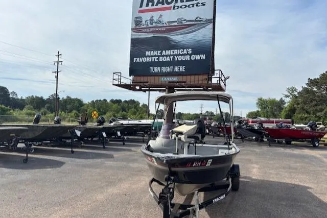 Slide: The Image of 2013 Tracker Super Guide V-16 SC boat displayed outdoors with promotional signage. - 9