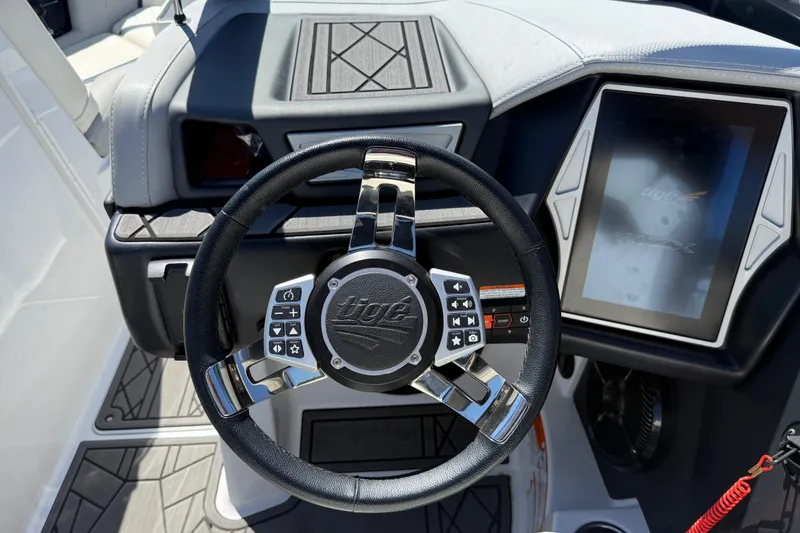 Slide: The Image of Steering wheel and dashboard of 2022 Tigé 21ZX boat, featuring modern controls and touchscreen display. - 12