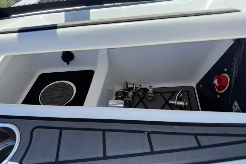 Slide: The Image of Storage compartment in 2022 Tigé 21ZX boat with metal fittings and red valve. - 14