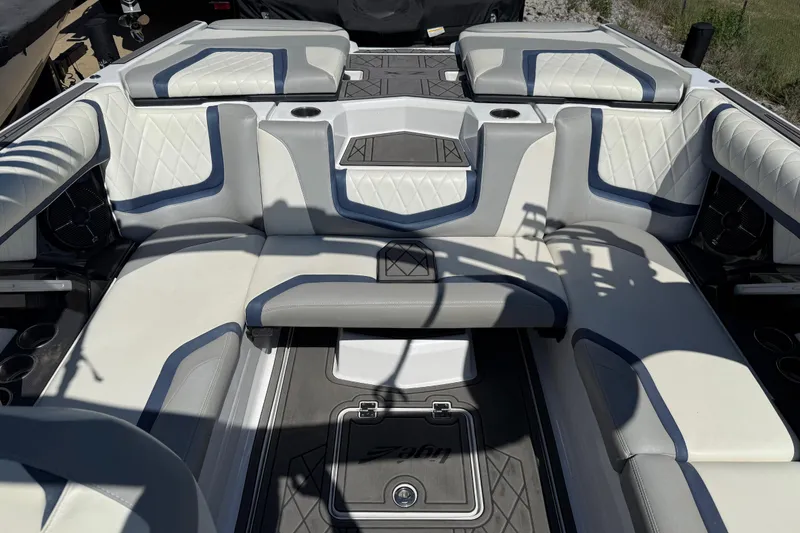 Slide: The Image of 2022 Tigé 21ZX boat interior with white and gray seating, diamond stitching, and cup holders. - 16