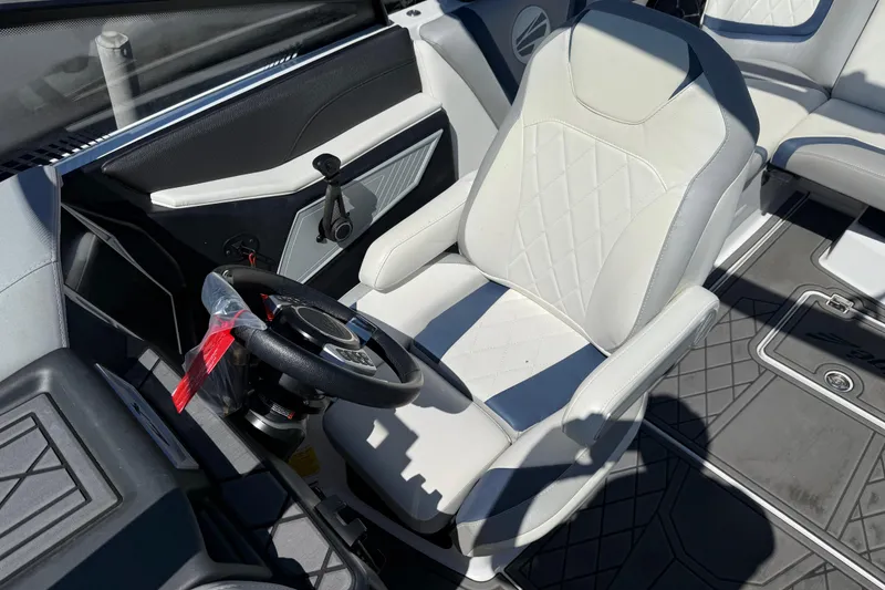Slide: The Image of 2022 Tigé 21ZX boat interior with white captain's seat and steering wheel. - 7