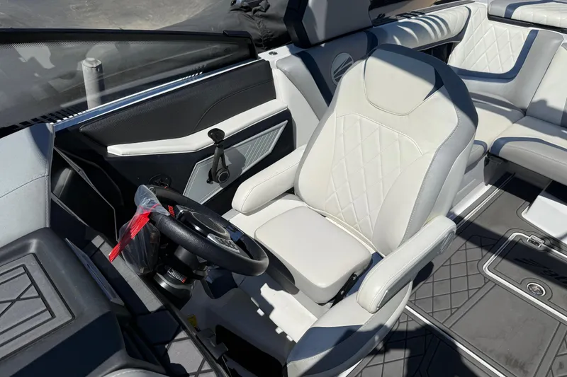 Slide: The Image of 2022 Tigé 21ZX boat interior with white leather seating and steering wheel. - 8