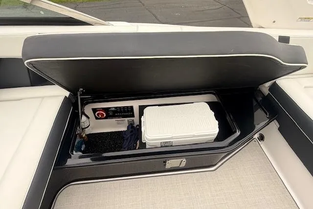 Slide: The Image of Storage compartment of 2021 Regal 2800 Bowrider with cooler and control panel. - 29