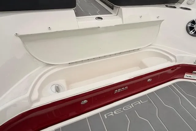 Slide: The Image of 2021 Regal 2800 Bowrider boat interior with storage compartment and branded flooring. - 33