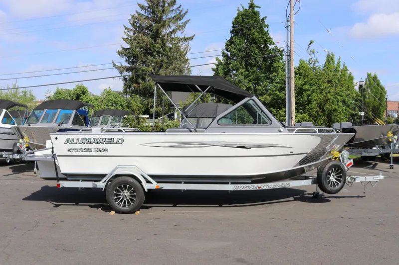 The Image of 2026 Alumaweld Stryker X202 boat on trailer, parked outdoors, under clear sky. - 1