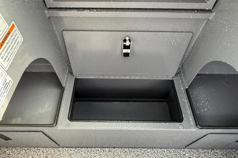 Slide: The Image of 2026 Alumaweld Stryker X202 storage compartment with water droplets and safety warning label. - 18