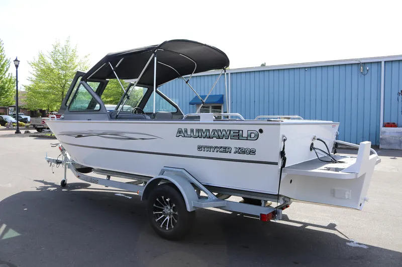 Slide: The Image of 2026 Alumaweld Stryker X202 boat on trailer, parked outdoors near blue building. - 3