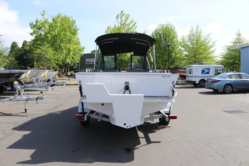 Slide: The Image of 2026 Alumaweld Stryker X202 boat on trailer, parked outdoors with trees and vehicles nearby. - 4