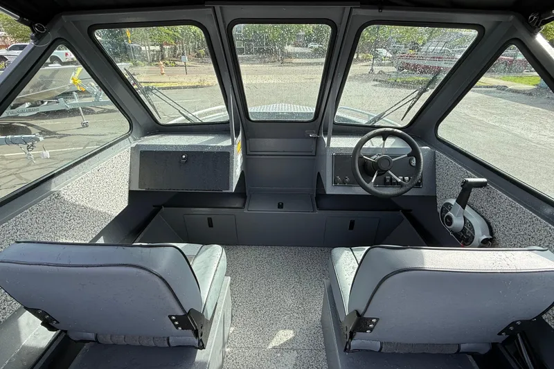 Slide: The Image of Interior of 2026 Alumaweld Stryker X202 boat, featuring steering wheel and dual seats. - 6