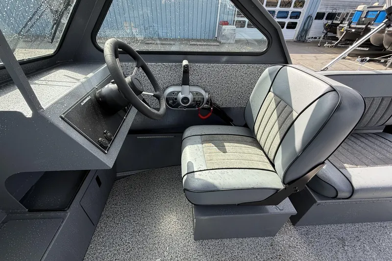 Slide: The Image of 2026 Alumaweld Stryker X202 boat interior with steering wheel and cushioned seating. - 7