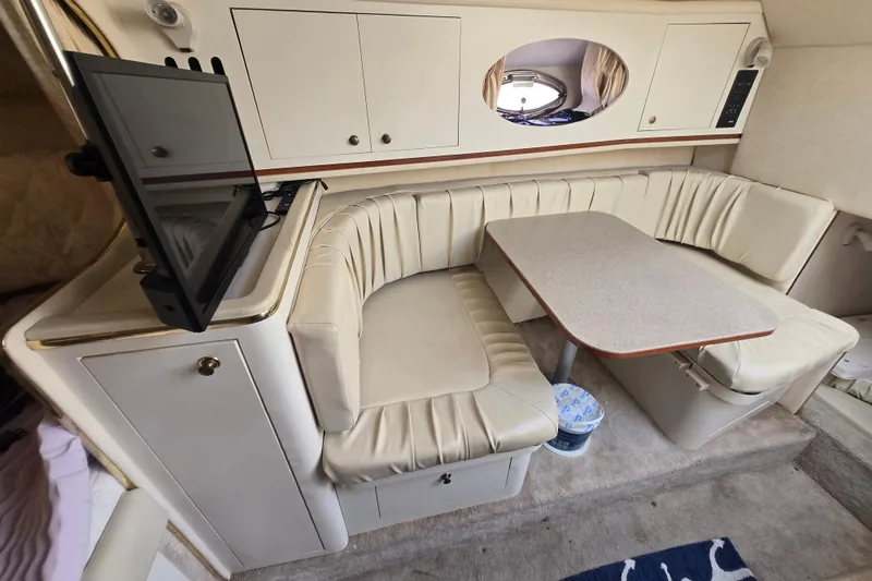 Slide: The Image of Interior of a 2000 Sea Ray 290 Amberjack boat with a cozy dining area. - 15