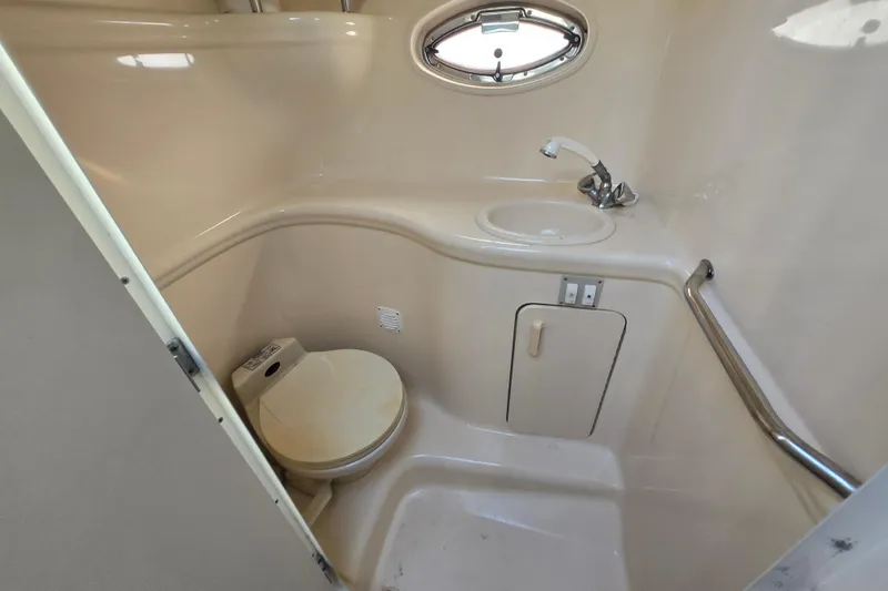 Slide: The Image of Compact bathroom in a 2000 Sea Ray 290 Amberjack boat, featuring a toilet and sink. - 17