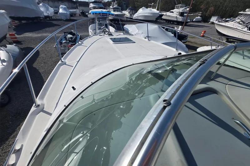 Slide: The Image of 2000 Sea Ray 290 Amberjack boat on display in a marina with other vessels. - 23