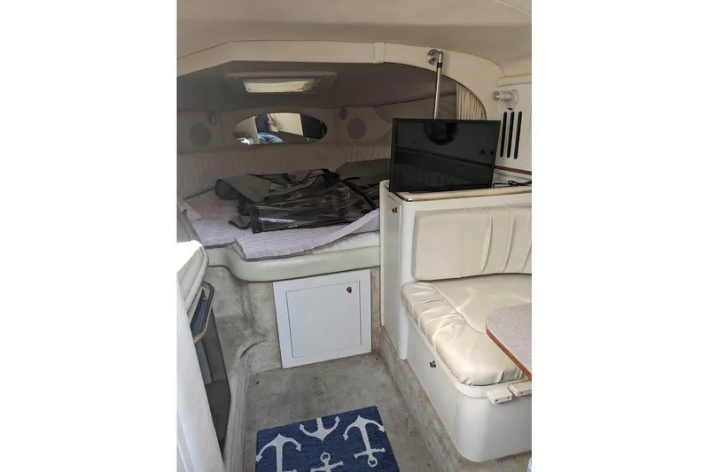Slide: The Image of Interior of 2000 Sea Ray 290 Amberjack boat with seating and a small TV. - 29