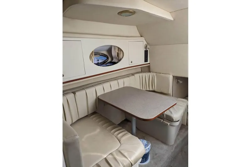 Slide: The Image of Interior of 2000 Sea Ray 290 Amberjack boat with beige seating and table. - 30