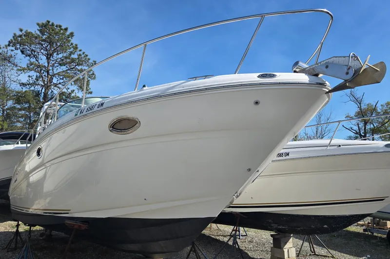 Slide: The Image of 2000 Sea Ray 290 Amberjack boat on dry dock under clear blue sky. - 5