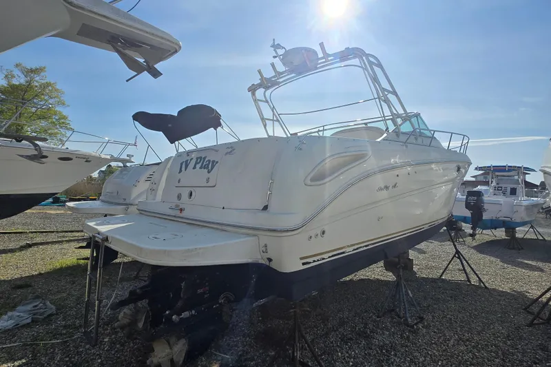 Slide: The Image of 2000 Sea Ray 290 Amberjack boat on stands under a clear blue sky. - 6