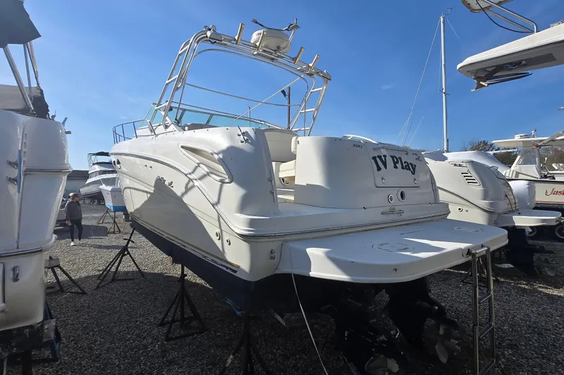 Slide: The Image of 2000 Sea Ray 290 Amberjack boat on stands, displayed outdoors under clear blue sky. - 9
