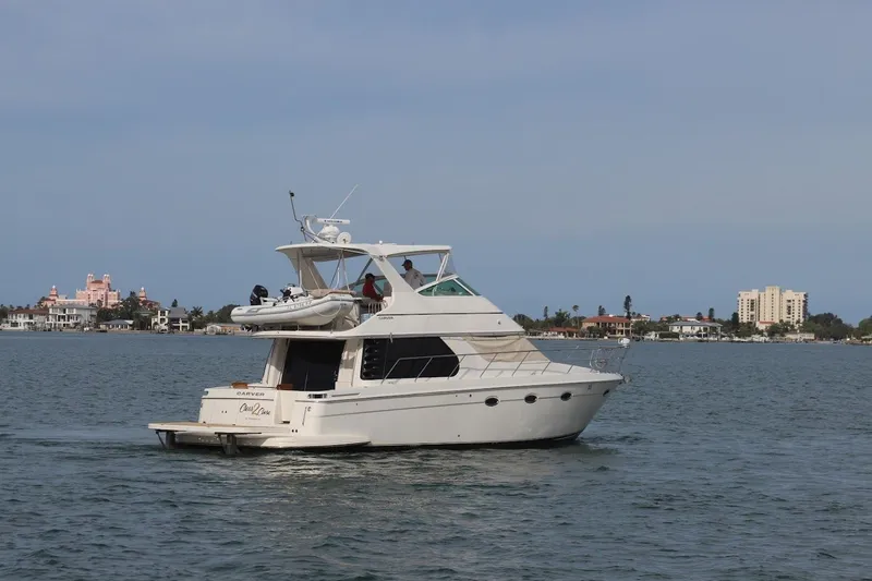 Slide: The Image of 2005 Carver 46 Voyager yacht on calm waters near coastal buildings. - 21