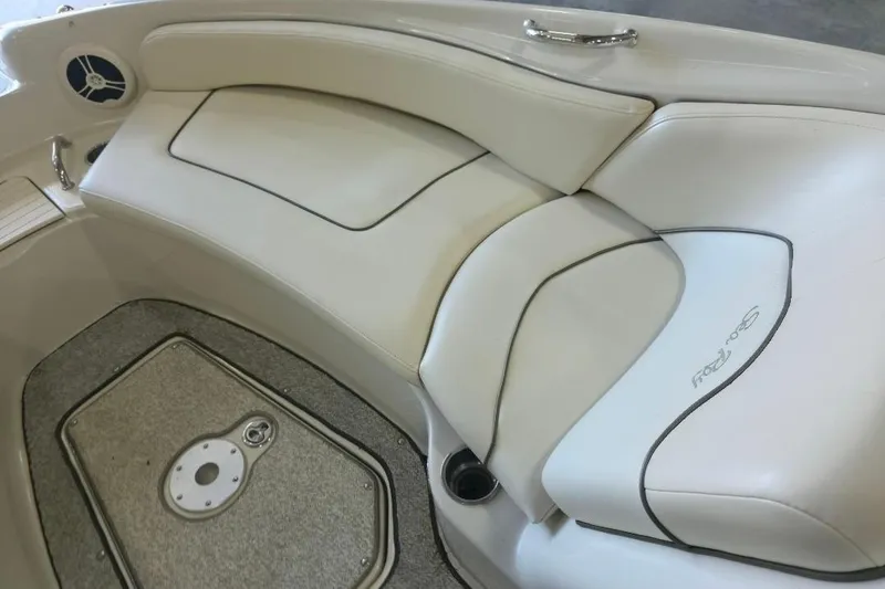 Slide: The Image of 2008 Sea Ray 240 Sundeck interior seating with white upholstery and speaker detail. - 13