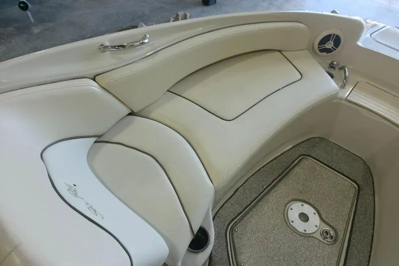 Slide: The Image of Interior seating of a 2008 Sea Ray 240 Sundeck boat, featuring white upholstery and carpeted flooring. - 14
