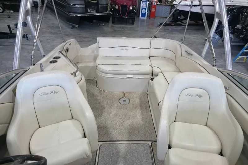 Slide: The Image of 2008 Sea Ray 240 Sundeck interior with white seating and carpeted floor in showroom. - 6