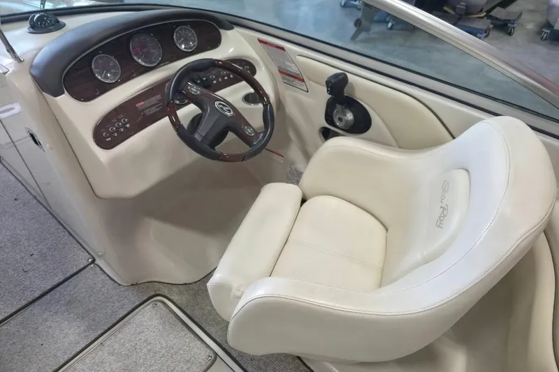 Slide: The Image of 2008 Sea Ray 240 Sundeck helm with steering wheel and white captain's chair. - 8