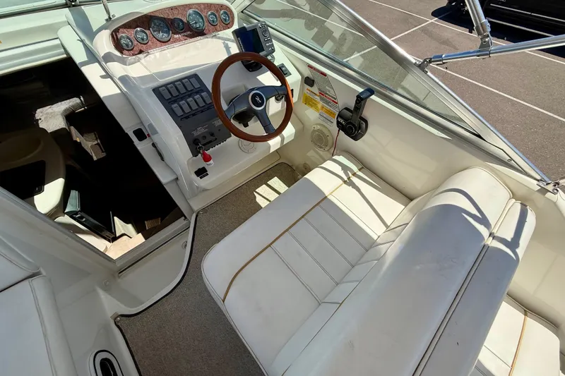 Slide: The Image of 1996 Sea Ray 250 Sundancer boat cockpit with steering wheel and control panel. - 10