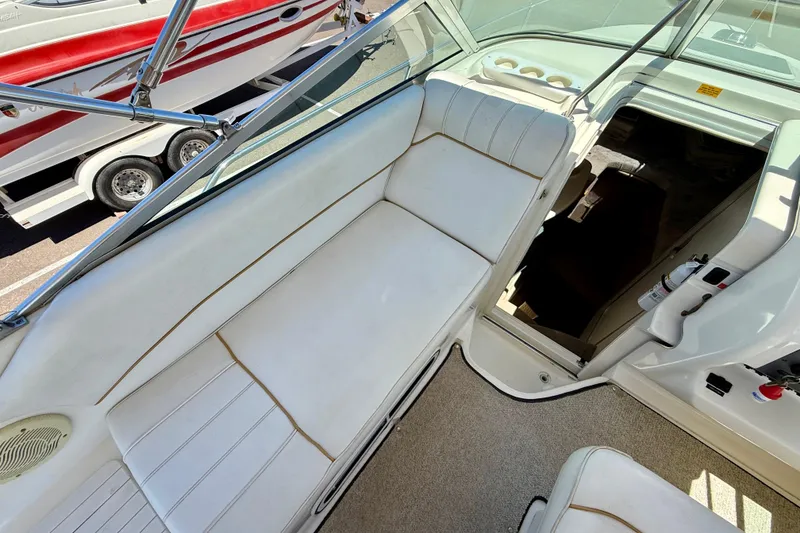 Slide: The Image of 1996 Sea Ray 250 Sundancer interior with white seating and open cabin entrance. - 11
