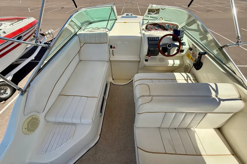 Slide: The Image of 1996 Sea Ray 250 Sundancer boat interior with white seating and control panel. - 12