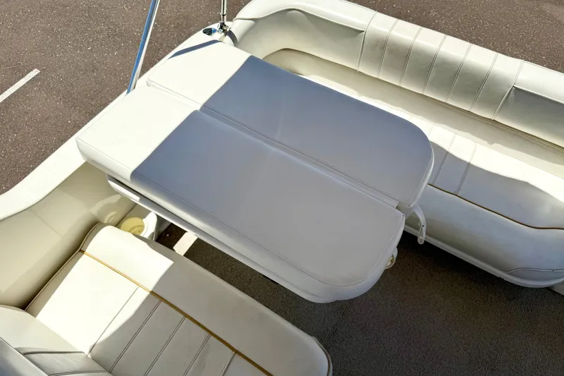 Slide: The Image of 1996 Sea Ray 250 Sundancer boat interior with white cushioned seating. - 14