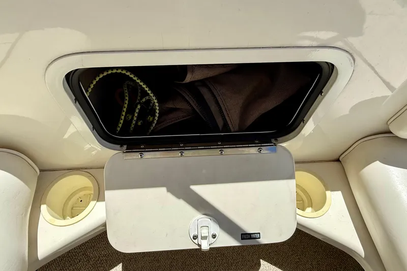 Slide: The Image of Storage compartment on a 1996 Sea Ray 250 Sundancer boat, open with items inside. - 19