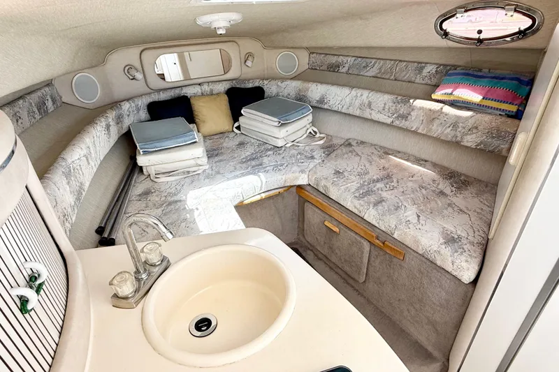 Slide: The Image of 1996 Sea Ray 250 Sundancer cabin interior with sink, seating, and porthole window. - 21