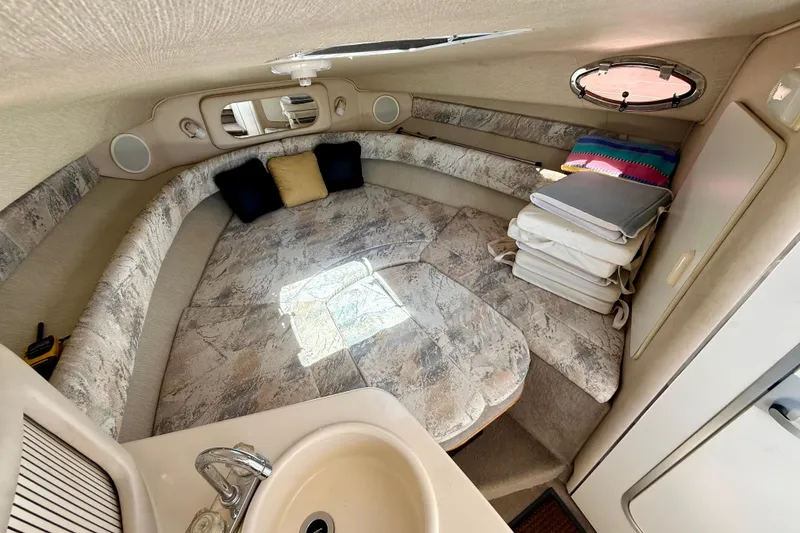 Slide: The Image of 1996 Sea Ray 250 Sundancer cabin interior with cozy seating and compact sink area. - 22