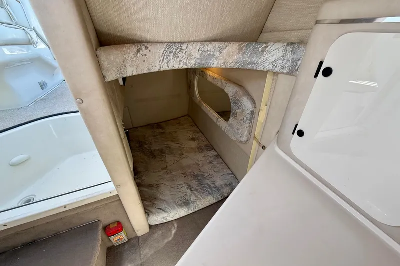Slide: The Image of Interior cabin of a 1996 Sea Ray 250 Sundancer boat, featuring cozy sleeping area. - 24