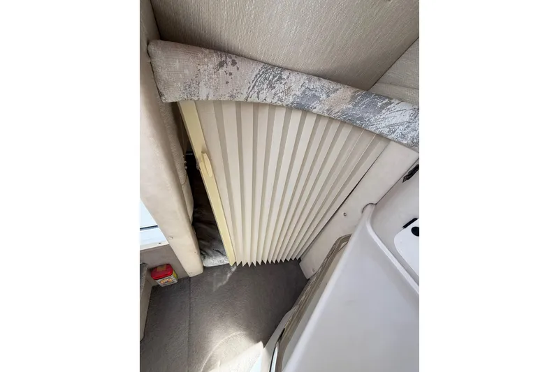 Slide: The Image of 1996 Sea Ray 250 Sundancer interior with pleated cabin door and carpeted floor. - 25